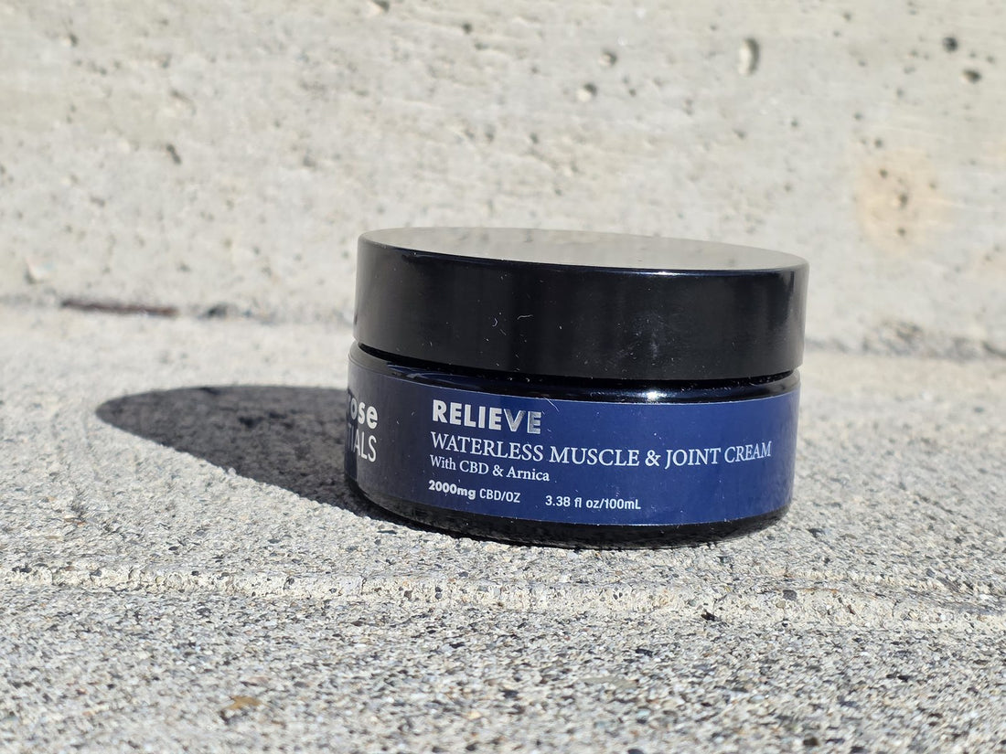 A jar of Melrose Relieve waterless CBD cream on a sunlit concrete step outdoors