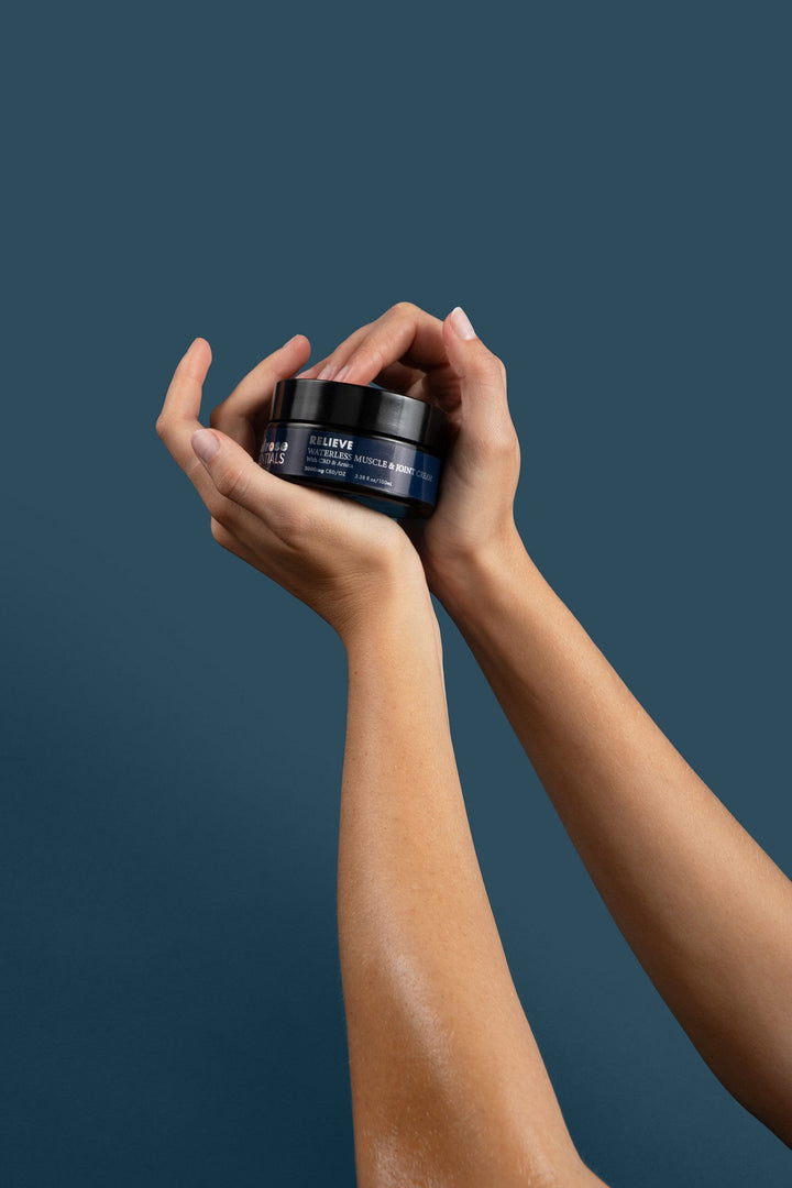 Two hands holding a jar of Melrose Relieve waterless CBD cream