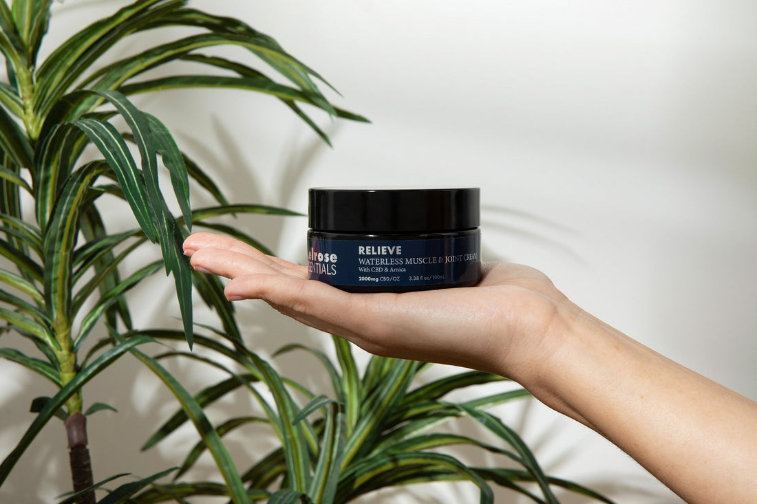 A jar of Melrose Relieve waterless CBD balm held in an open hand, the balm built at a Wenatchee massage clinic