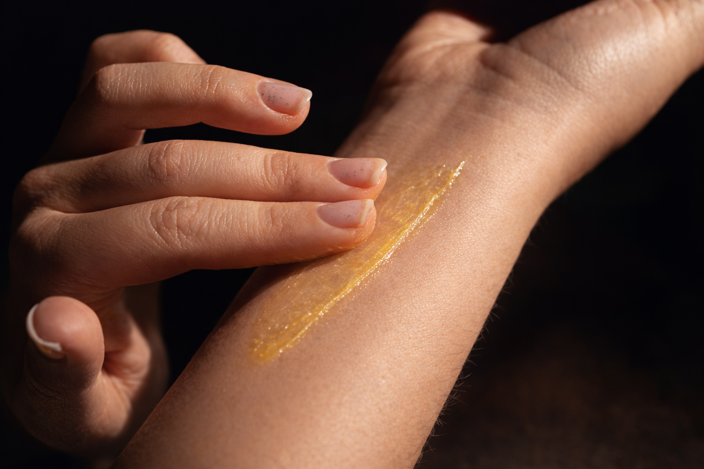Hand applying a Melrose Essentials Relieve CBD cream arm against a white background